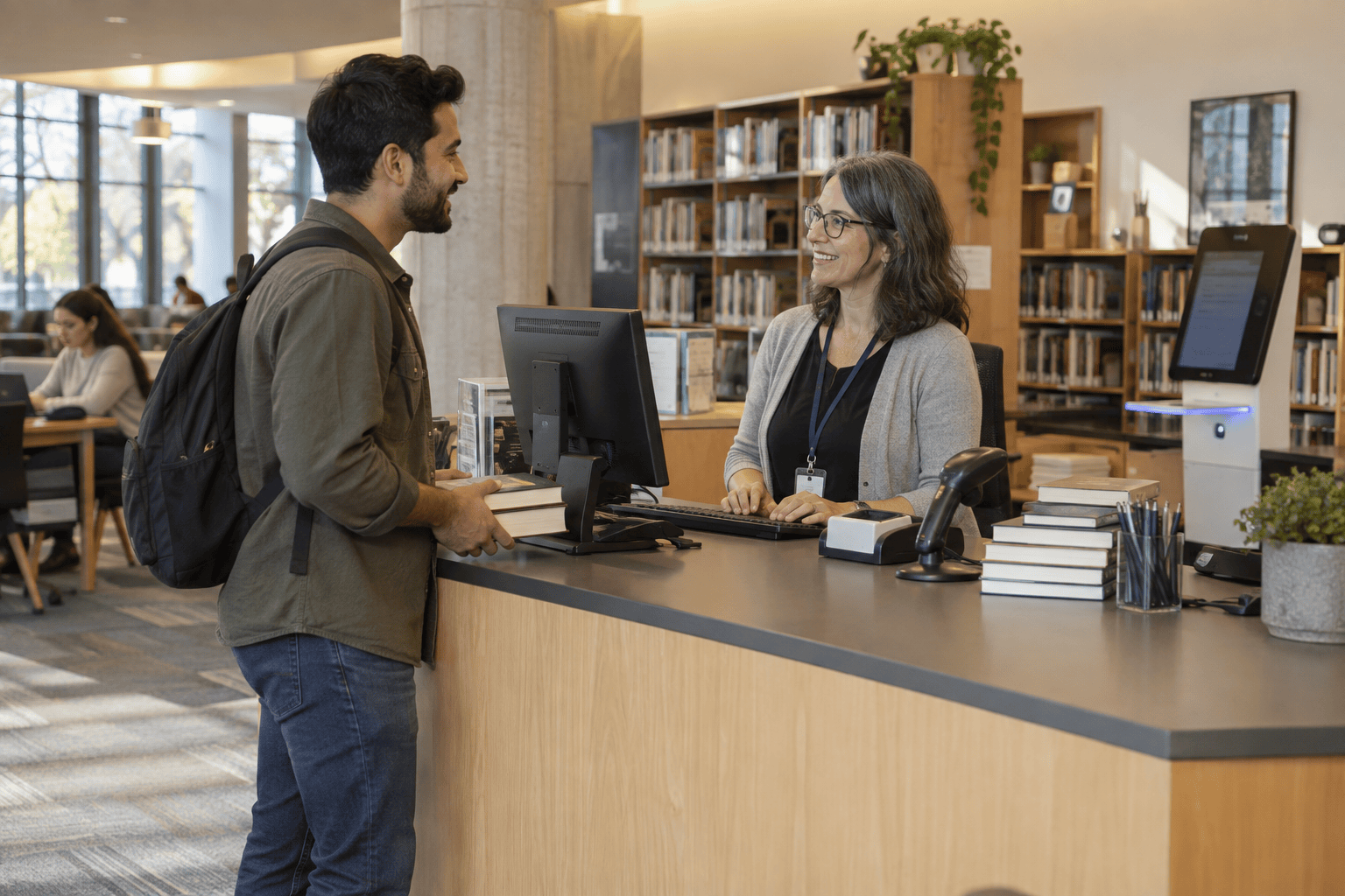 A student speaking with a staff member at a university library service desk.